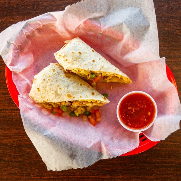 Two Uno Dos Tacos burritos filled with meat and vegetables, served with a side of salsa.